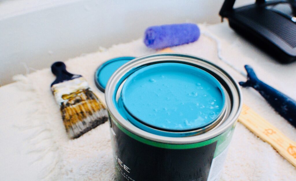 A paint can, brush, and other tools used by interior home painters.