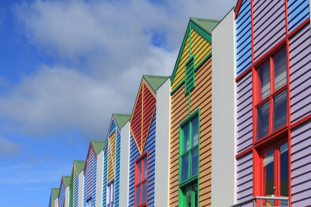 Colorful beach resort buildings in a row with a blue sky behind.