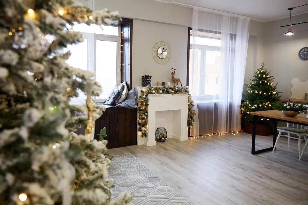 A Christmas decorated home interior with the side of a Christmas tree blurred from being close to the point of view.