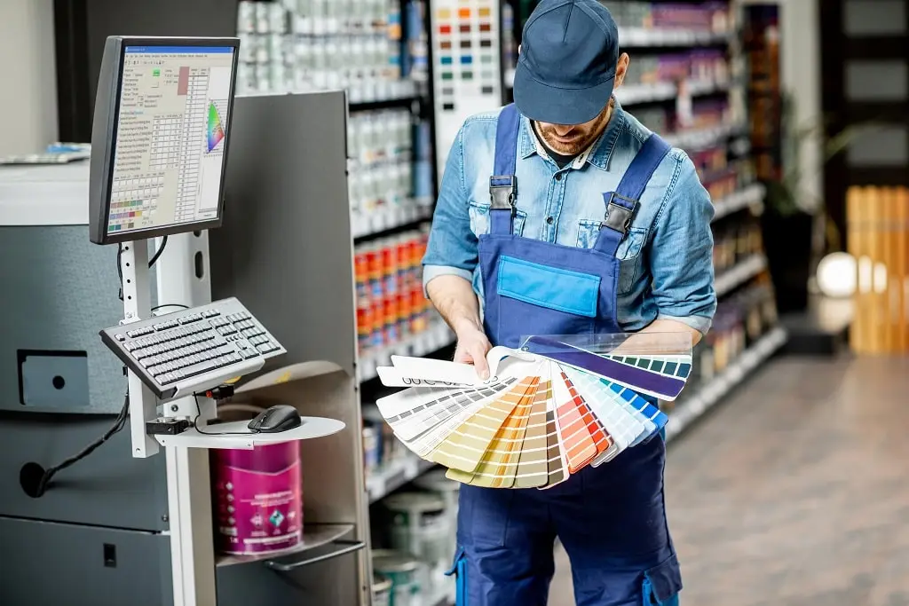 Workman with color swatches in a building shop.
