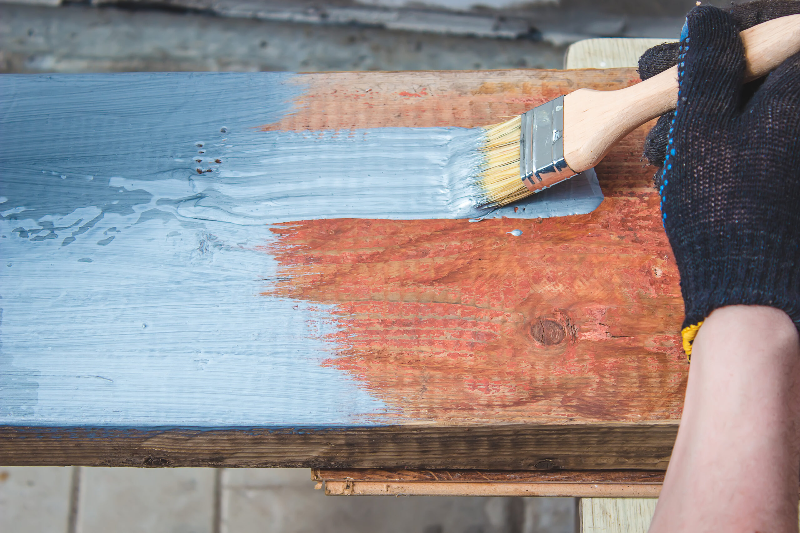 hand holds a brush, apply varnish paint on the board. board painting